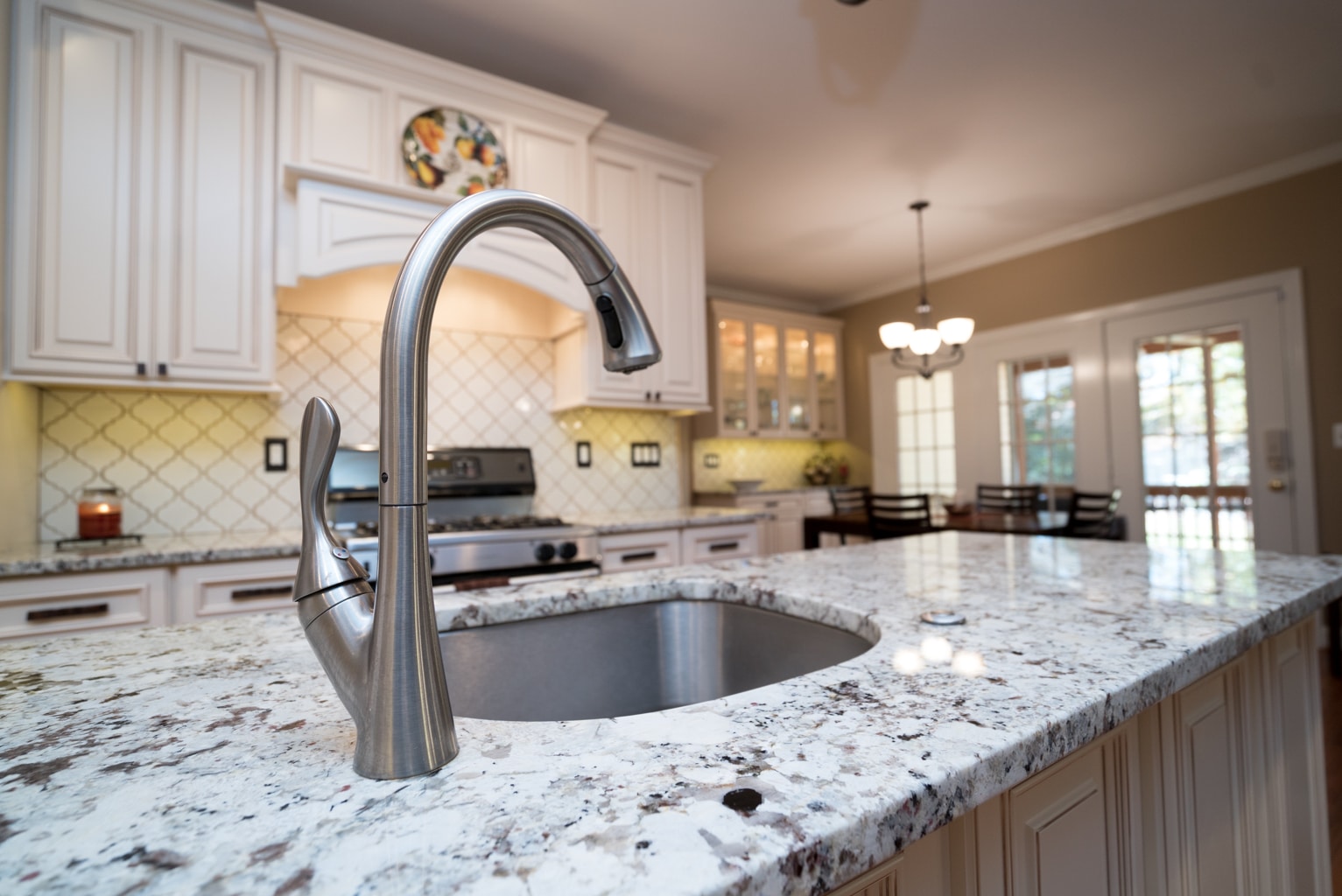 A modern kitchen with sleek granite countertops and a shiny stainless steel sink