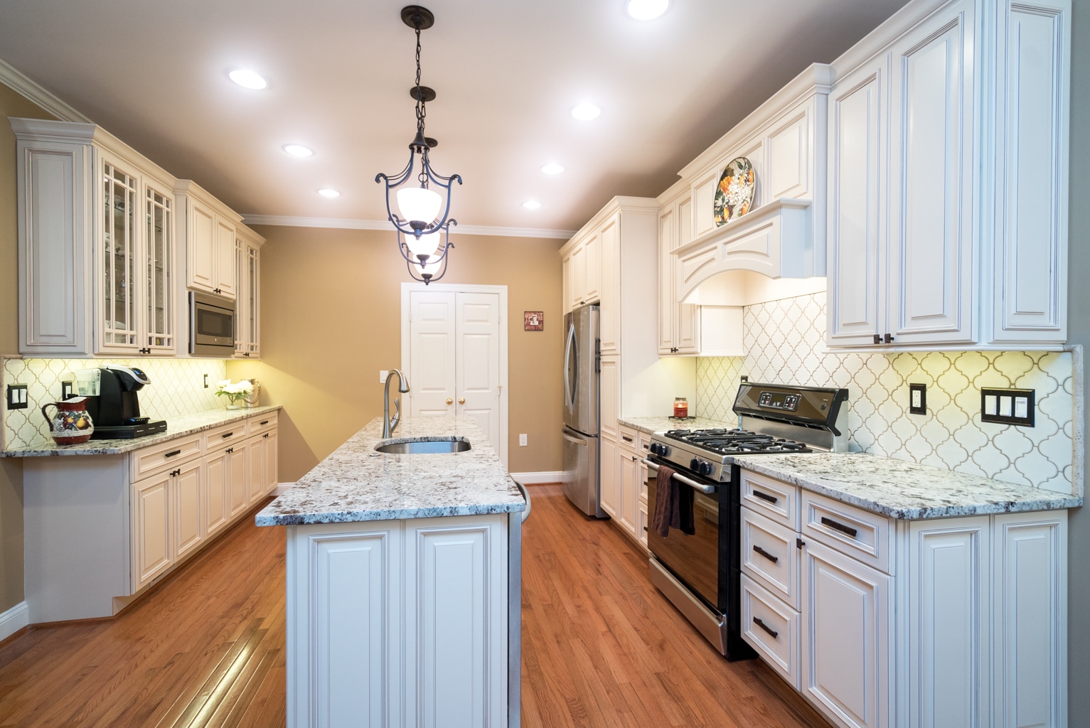 Kitchen with white cabinets and marble island