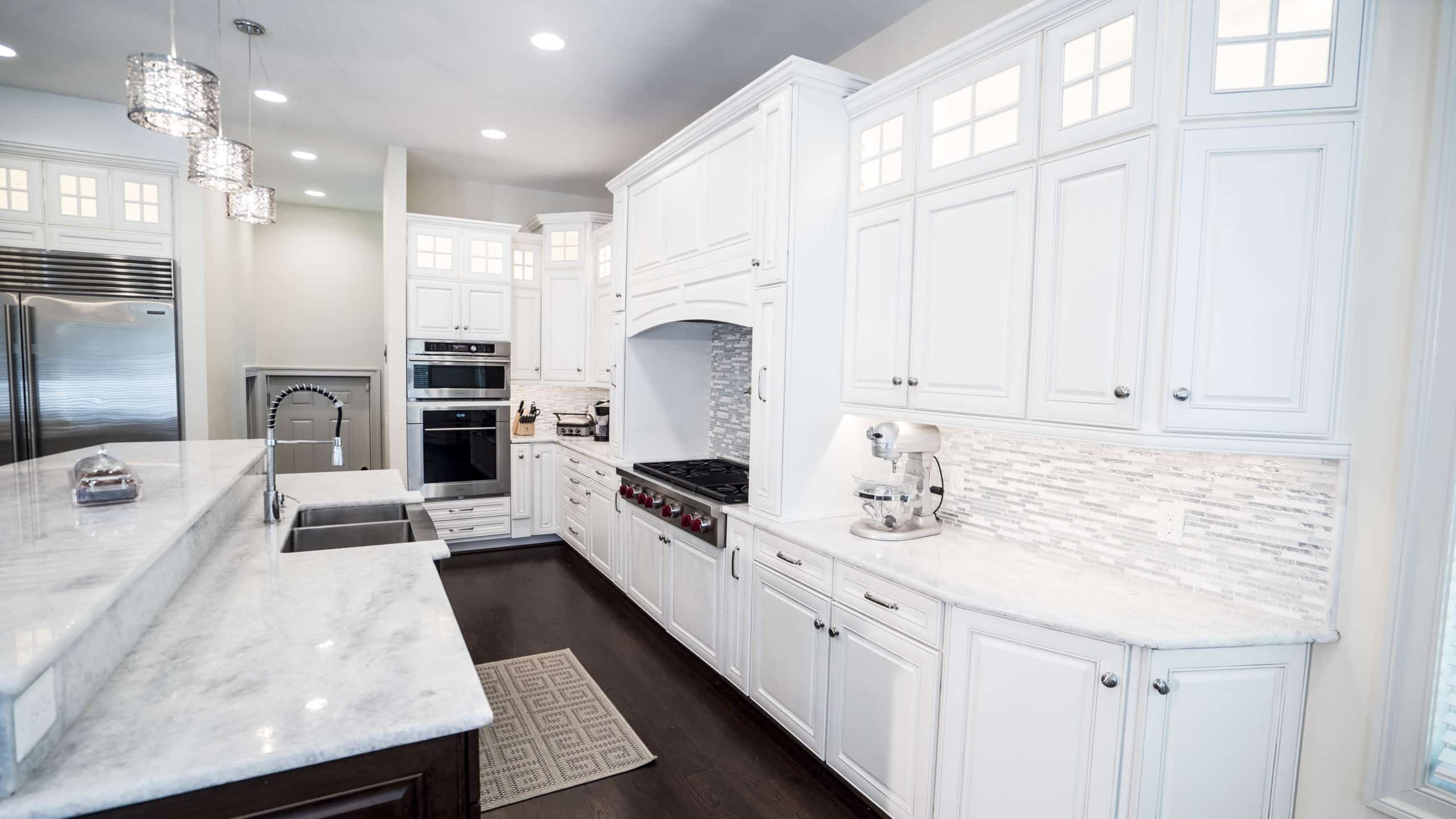 kitchen with white cabinets and marble counter tops, creating a sleek and elegant design