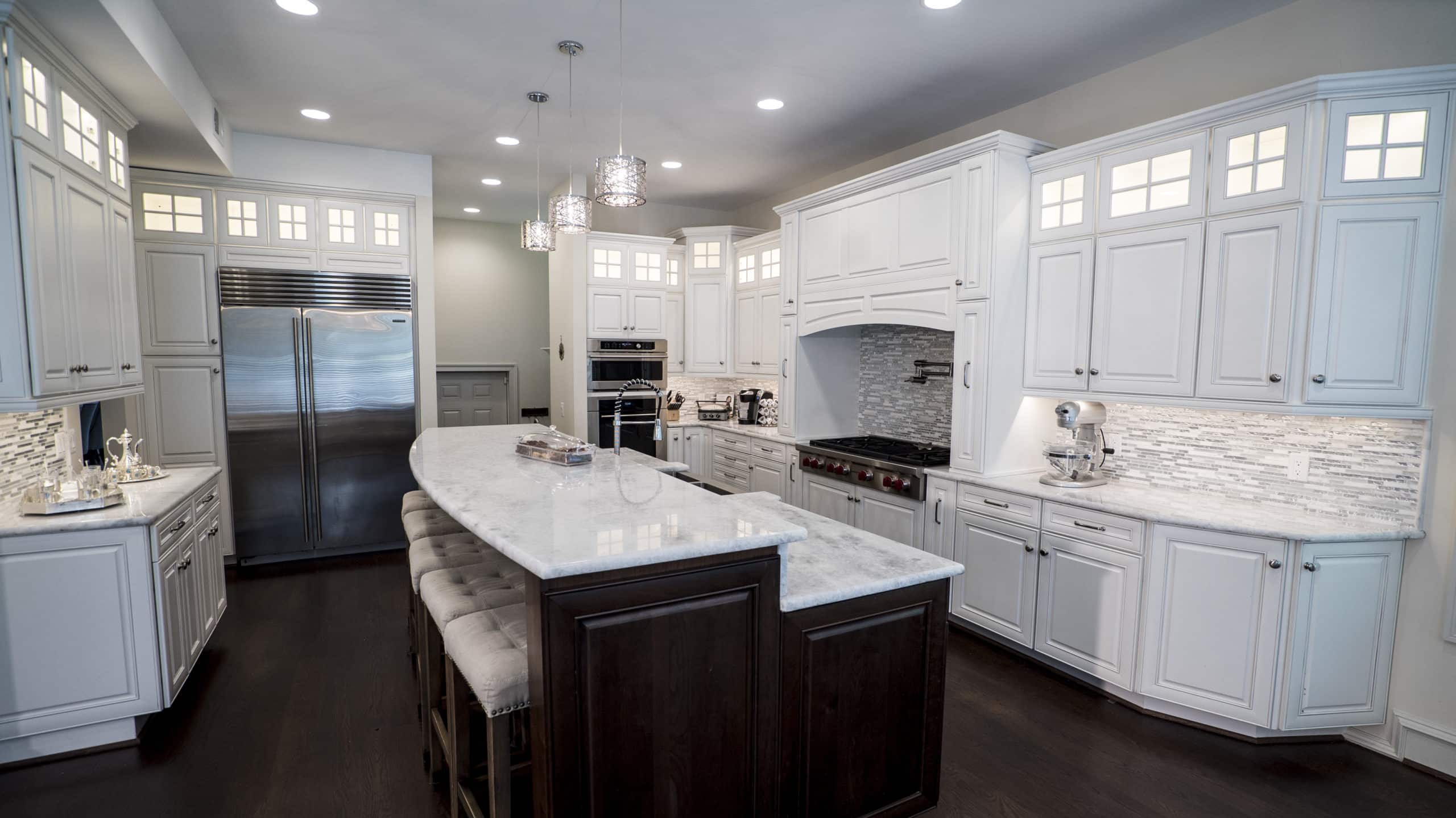 A spacious kitchen with white cabinets and a central island
