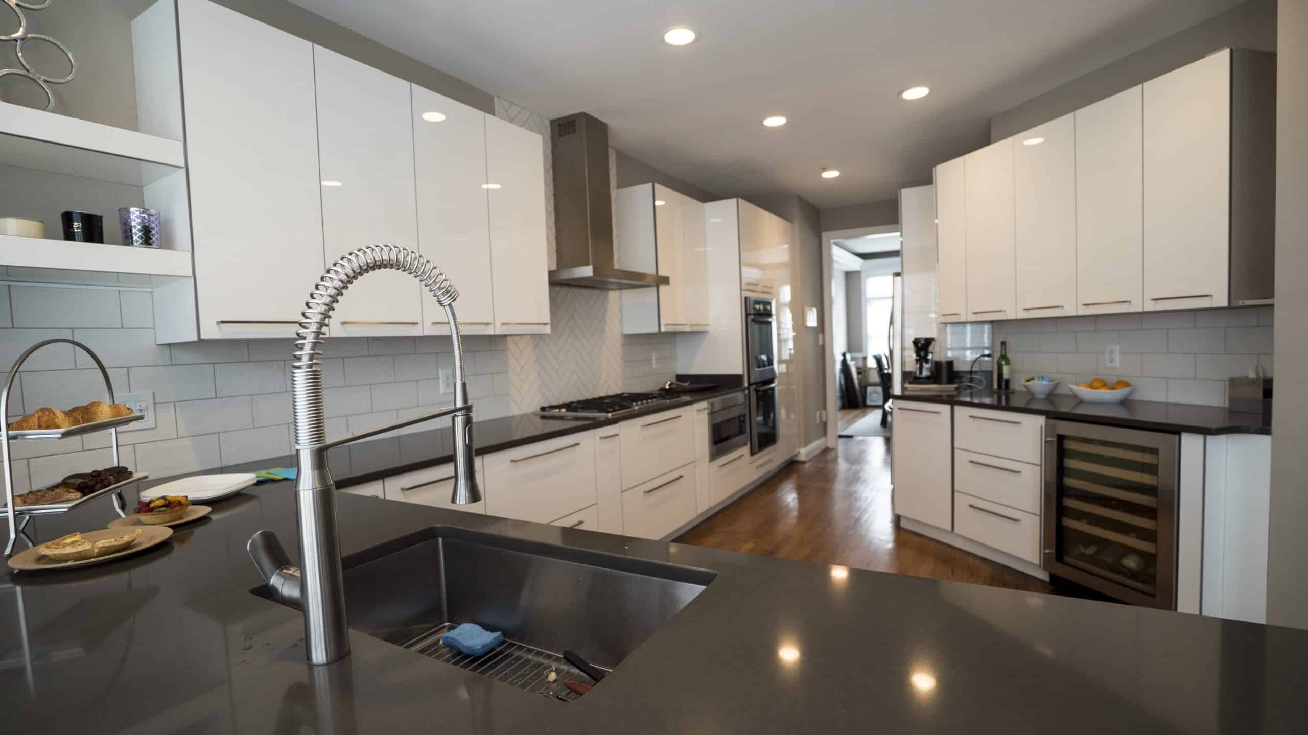 A modern kitchen with sleek stainless steel appliances and pristine white cabinets.