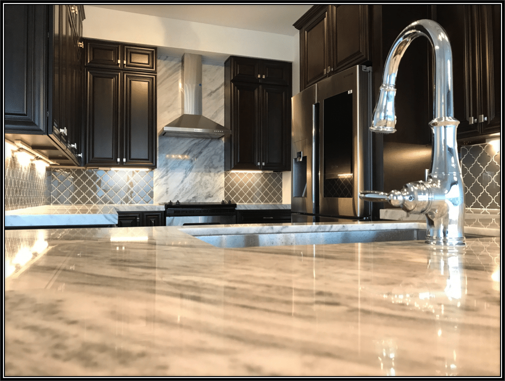 A modern kitchen with sleek black cabinets and elegant marble countertops