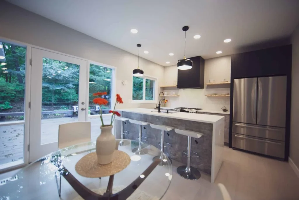 Modern kitchen with Perla White quartz waterfall island, black slab cabinetry, and Artesso by Brizo faucet
