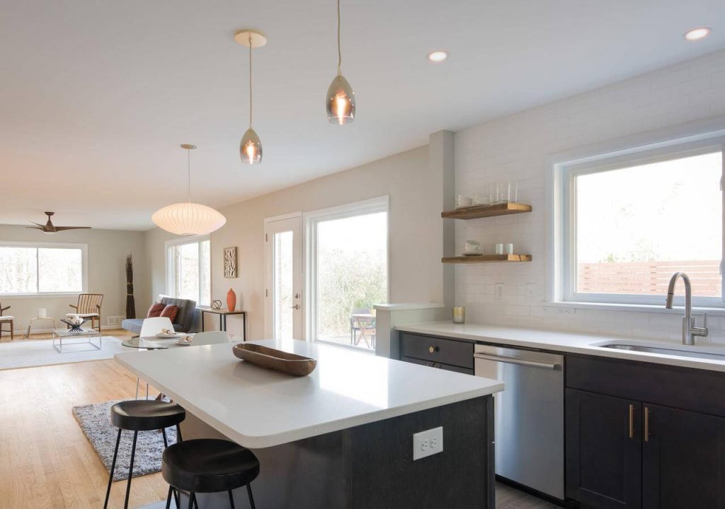 A kitchen with a central island and bar stools