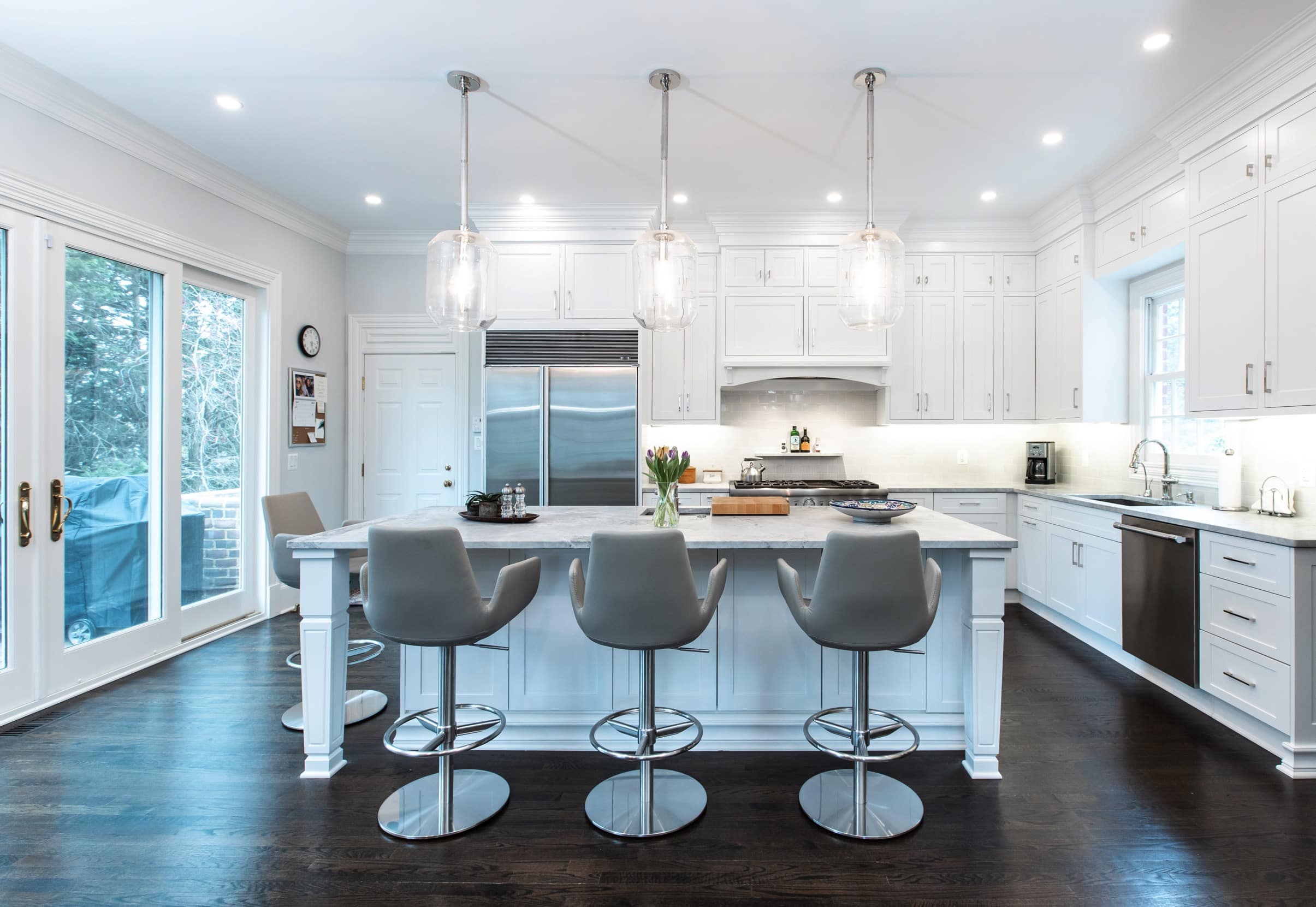 White kitchen cabinets paired with a light tile backsplash and stone countertops