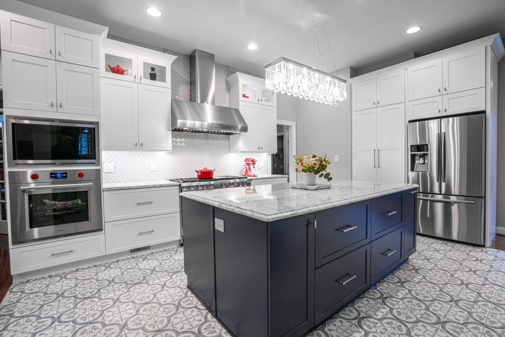 A kitchen with white cabinets and marble countertops