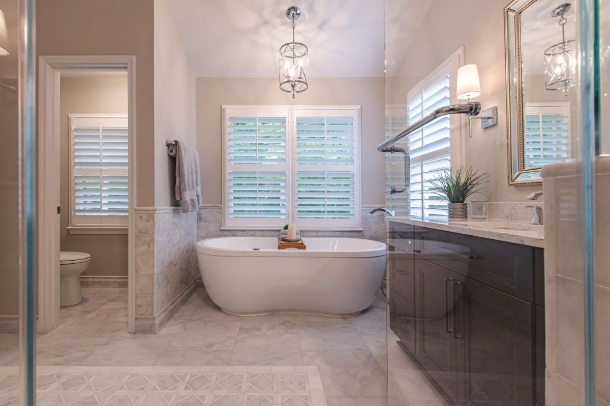 Master bathroom view with freestanding soaking tub, separate toilet room, and dark wood vanity in Ashburn VA.