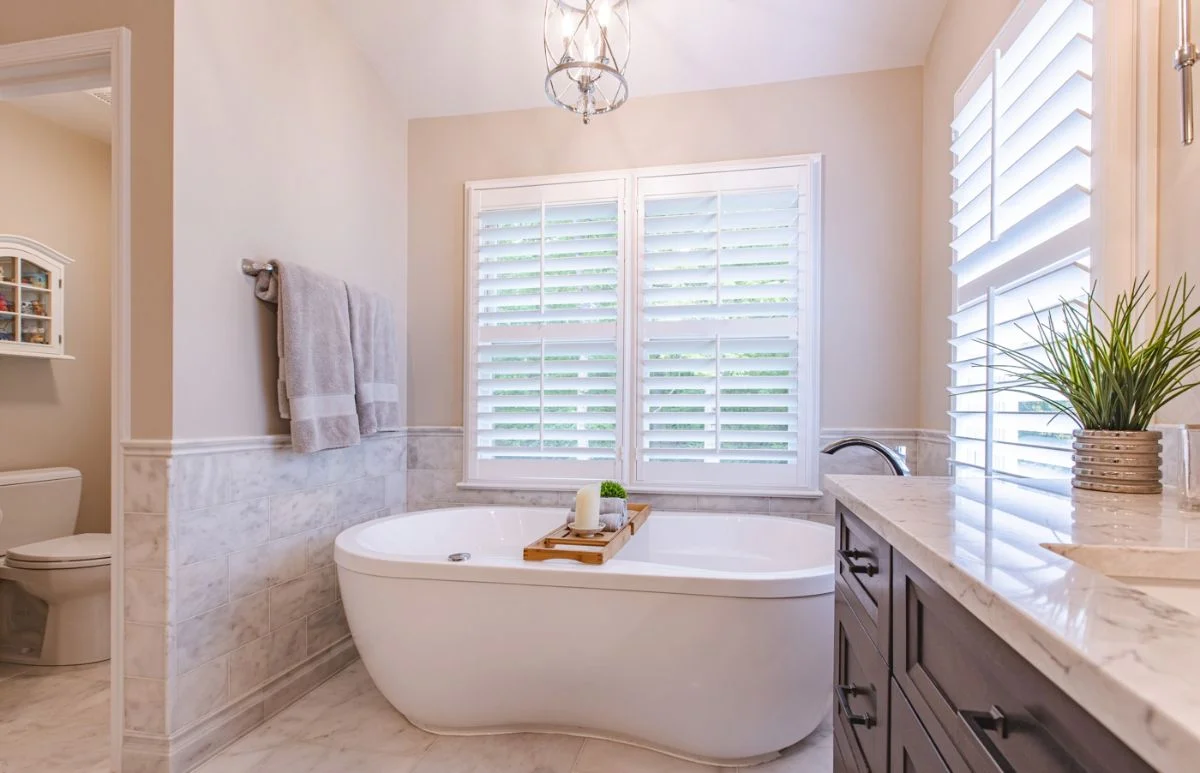 Master bathroom with freestanding tub, dark wood vanity, and separate toilet room in Ashburn VA.