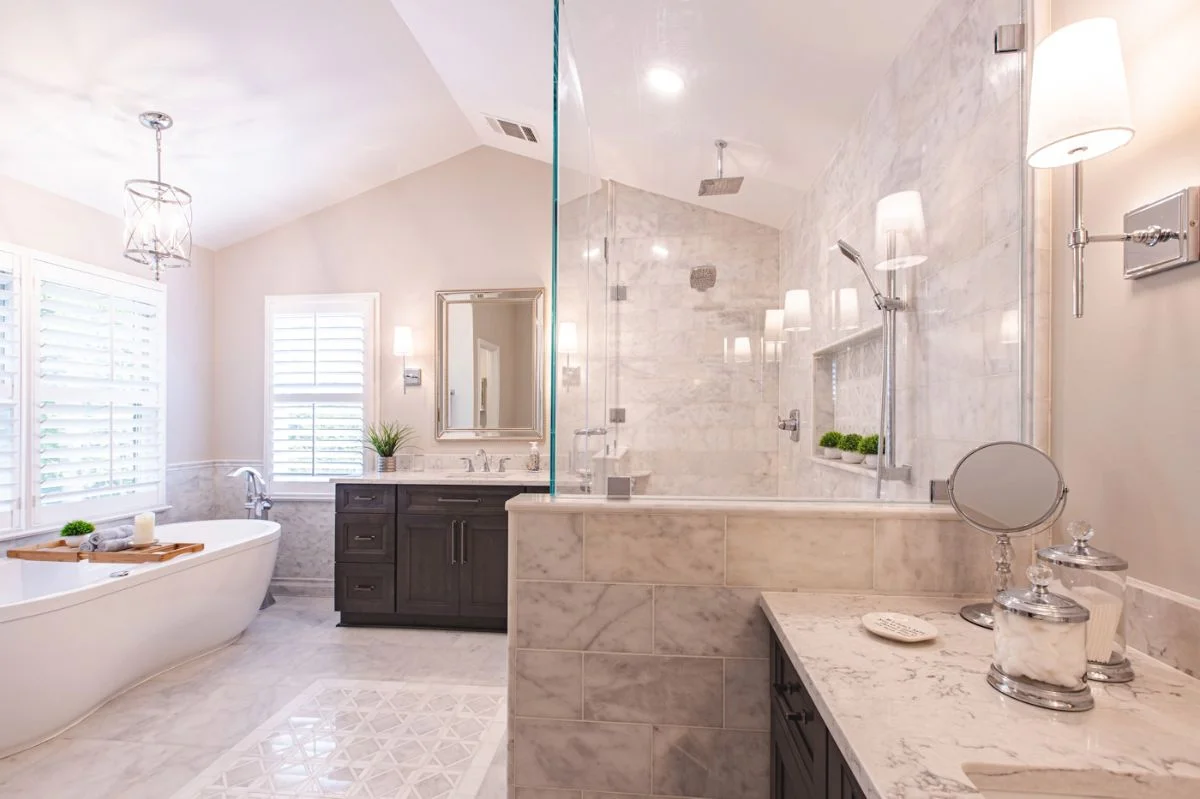 Modern master bathroom in Ashburn VA with freestanding tub, dark wood vanities, and marble glass-enclosed shower.