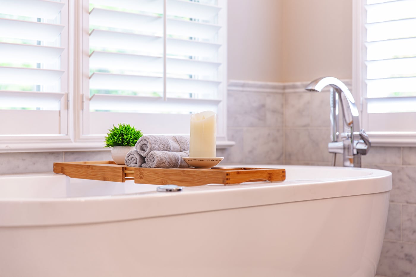 white bathtub with a candle and a towel