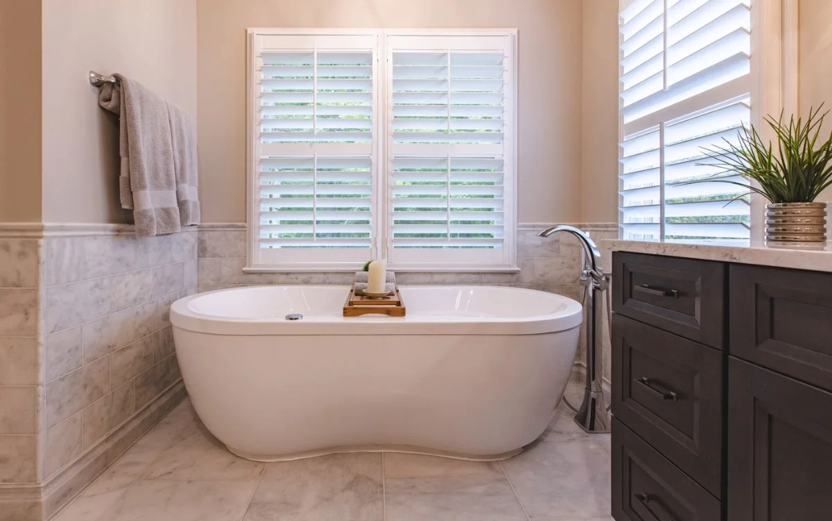White freestanding tub with chrome floor-mounted filler in an Ashburn VA bathroom renovation with marble wall tile.