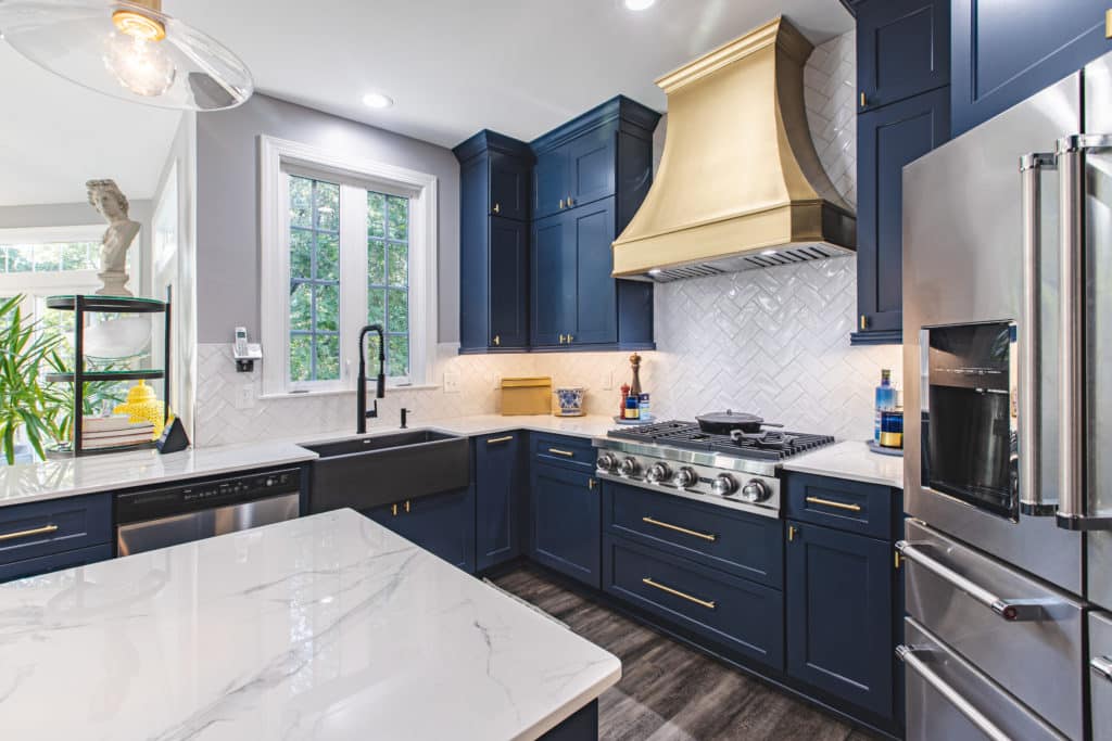 A kitchen with blue cabinets and white marble countertops
