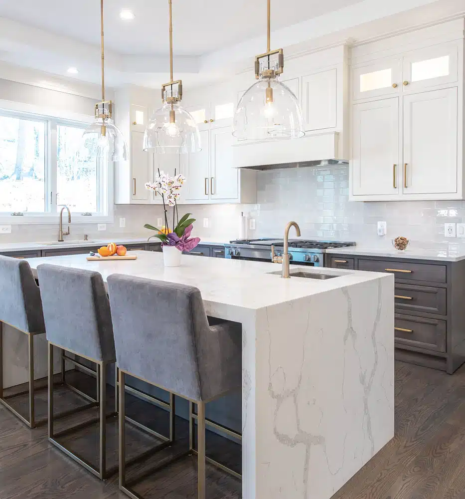 A kitchen with a marble island and chairs