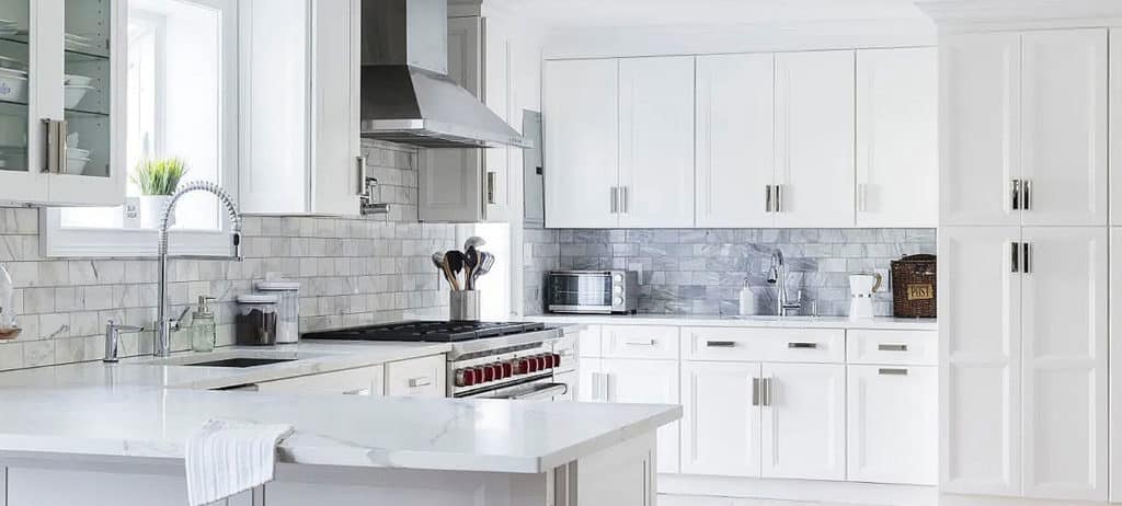 a kitchen with white cabinets and a large island