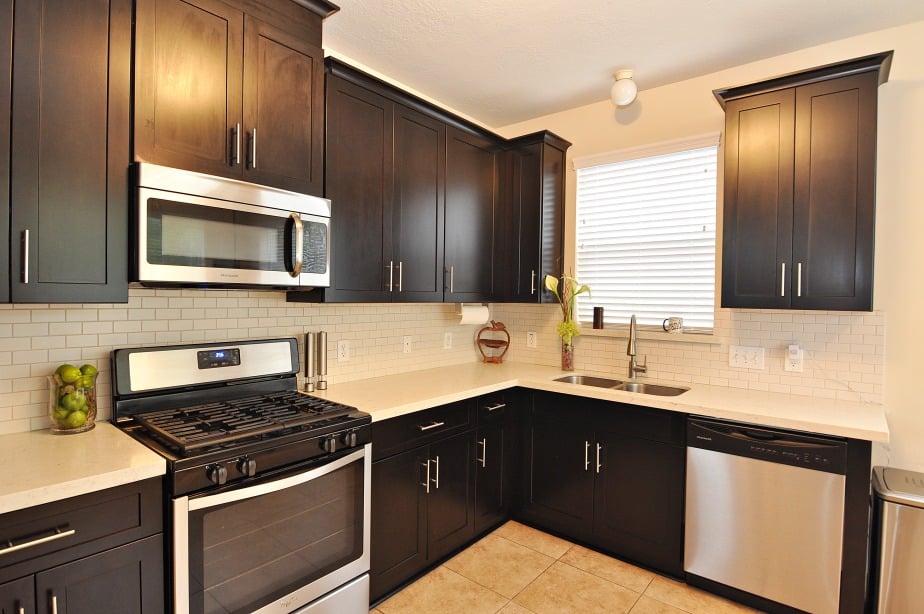 A modern kitchen with sleek black cabinets and stainless steel appliances