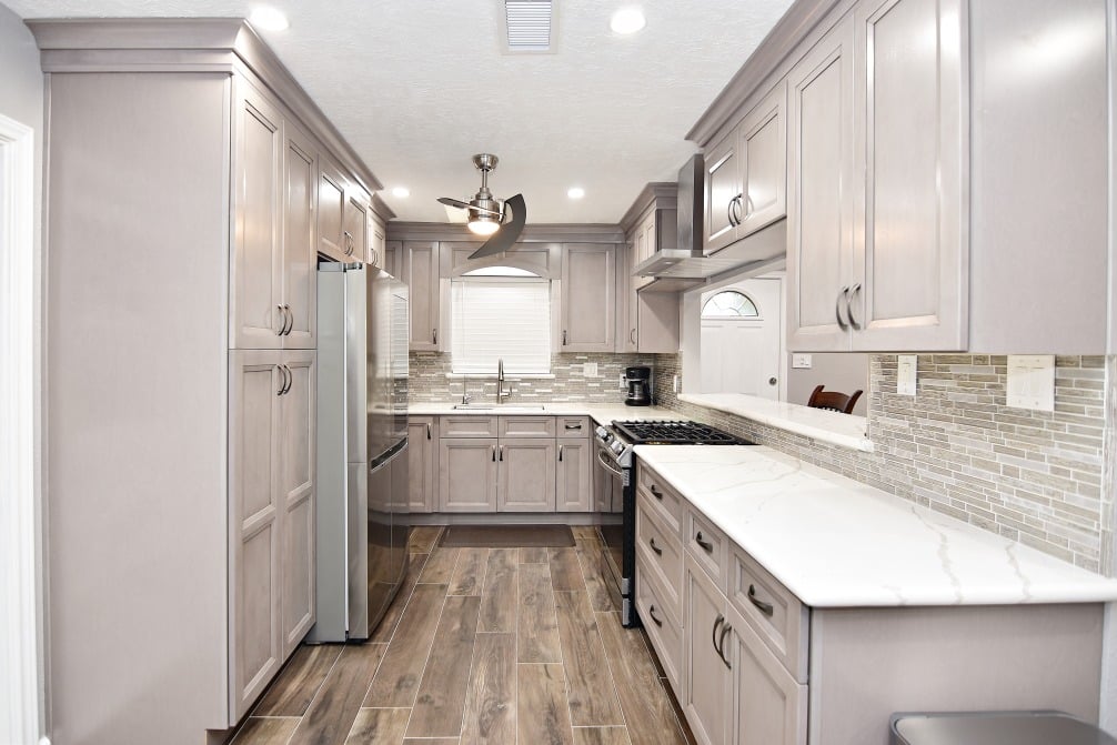 A kitchen with a white countertop and gray cabinets
