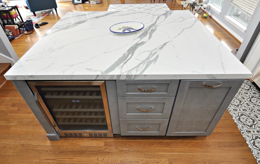 kitchen island with gray cabinets and marble countertops
