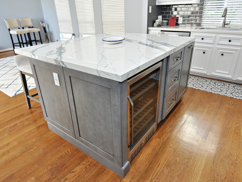 A kitchen island with gray cabinets