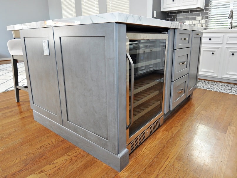 A kitchen island with a wine cooler