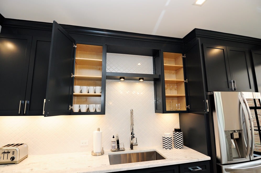A kitchen with sleek black cabinets and modern stainless steel appliances