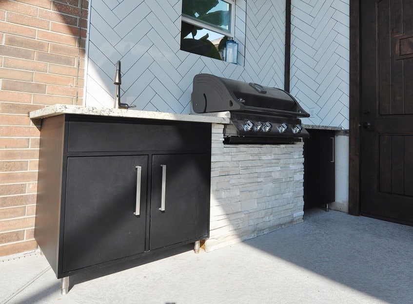 Outdoor kitchen with black cabinets and grill