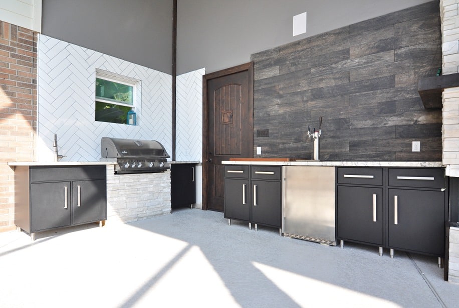 A kitchen with sleek black cabinets and a built-in grill