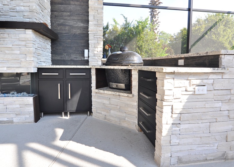 A kitchen with a stone countertop and a grill