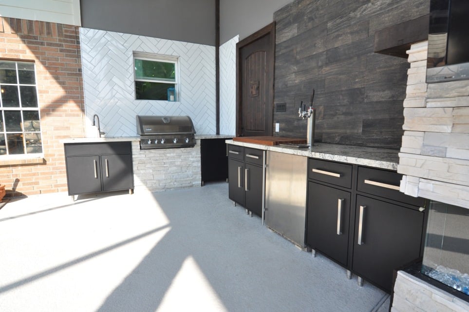 A kitchen with sleek black cabinets and a rustic brick