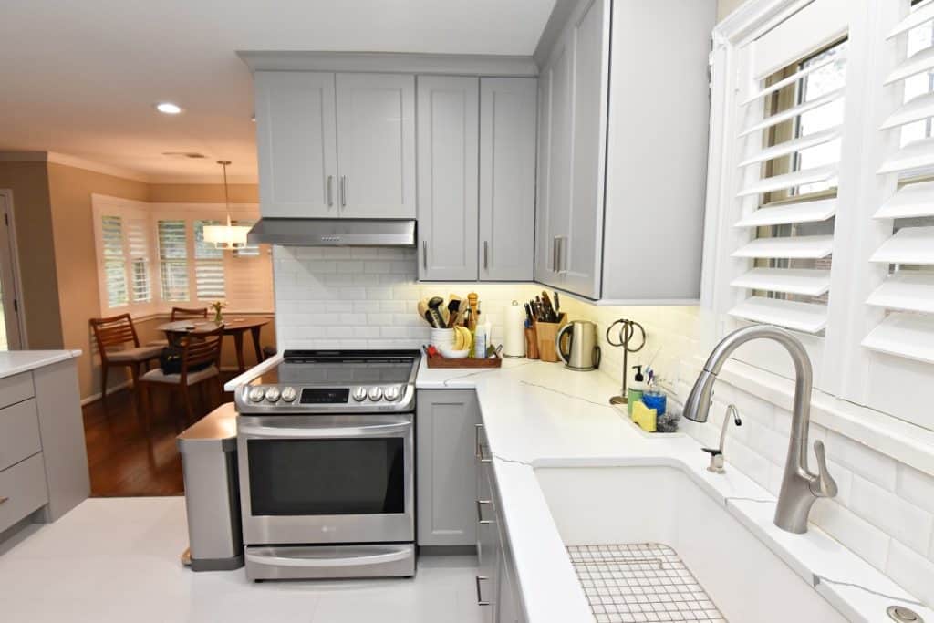 A modern kitchen with sleek stainless steel appliances and pristine gray cabinets