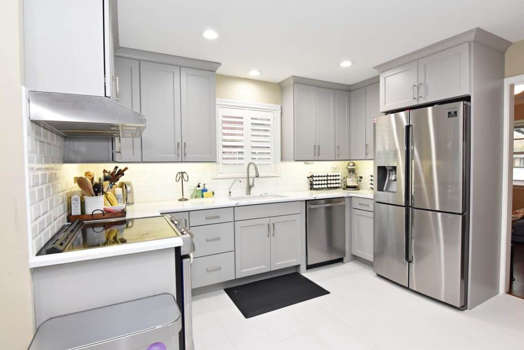 A Small kitchen with a gray cabinet, a sink and appliances