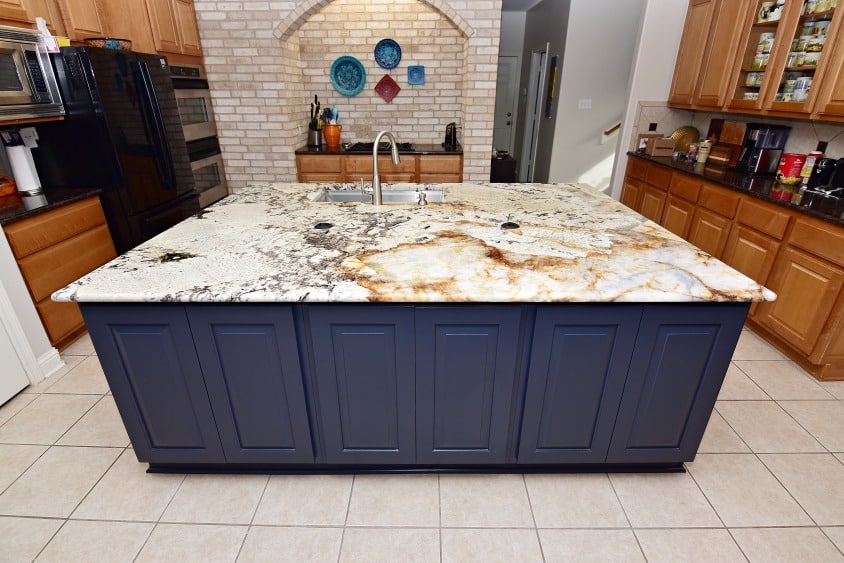 A kitchen with a sleek granite countertop and vibrant blue cabinets