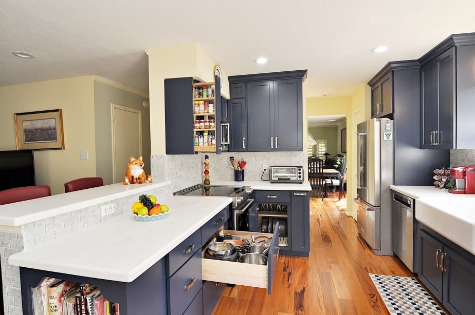A kitchen with a blue kitchen cabinets, a fridge, and a stove