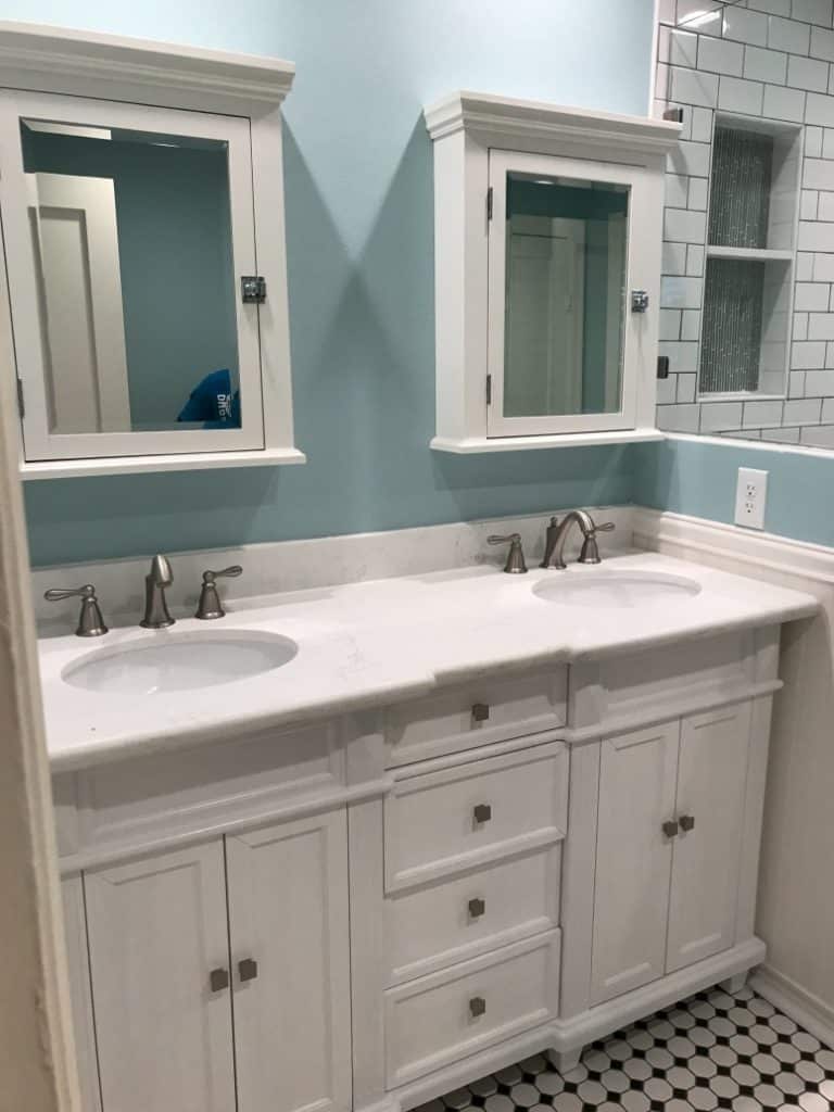 Small Bathroom Renovation Project in Houston, TX 24 Blue-walled bathroom with white cabinets