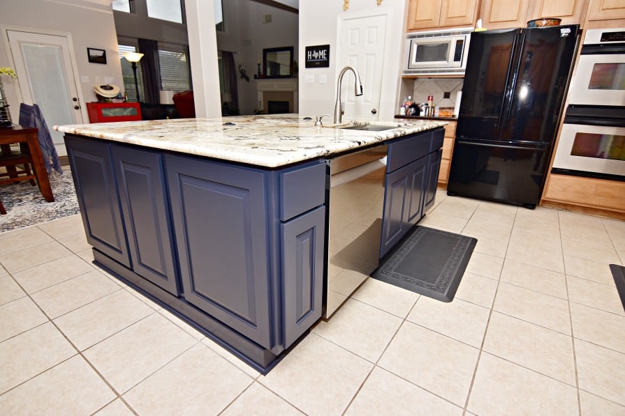 How Much Does a Kitchen Remodel Cost in 2026? 15 Navy kitchen island with raised panel cabinets, stone countertop, and integrated dishwasher Medium Kitchens (70–150 Square Feet)