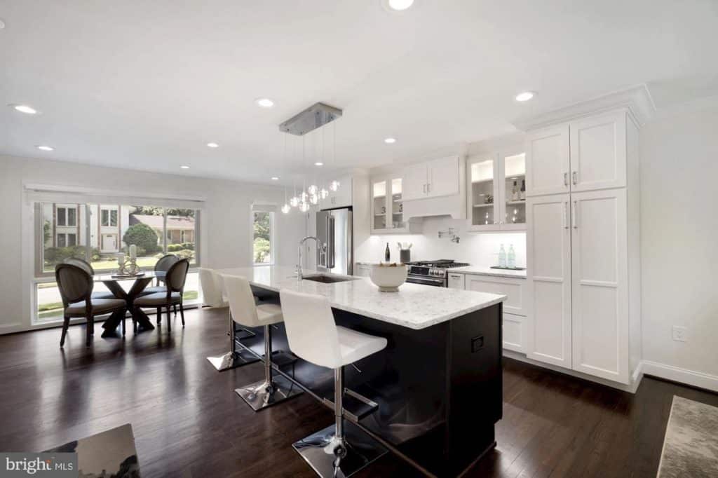 A kitchen with sleek white cabinets and contrasting black countertops