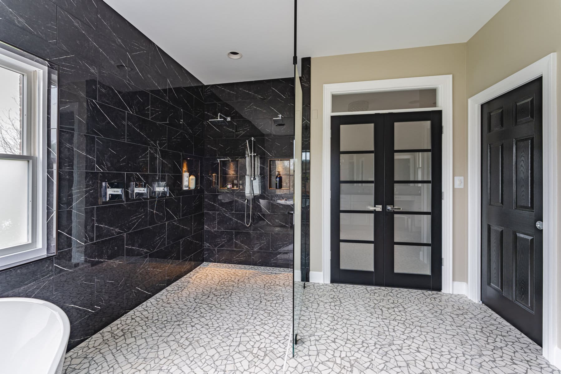 a bathroom with a marble floor and black walls