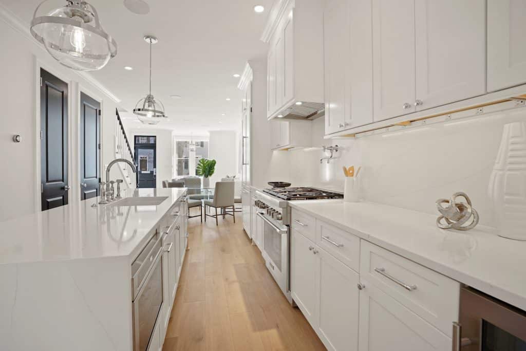 A spacious white kitchen with a sizable island and an adjoining dining room
