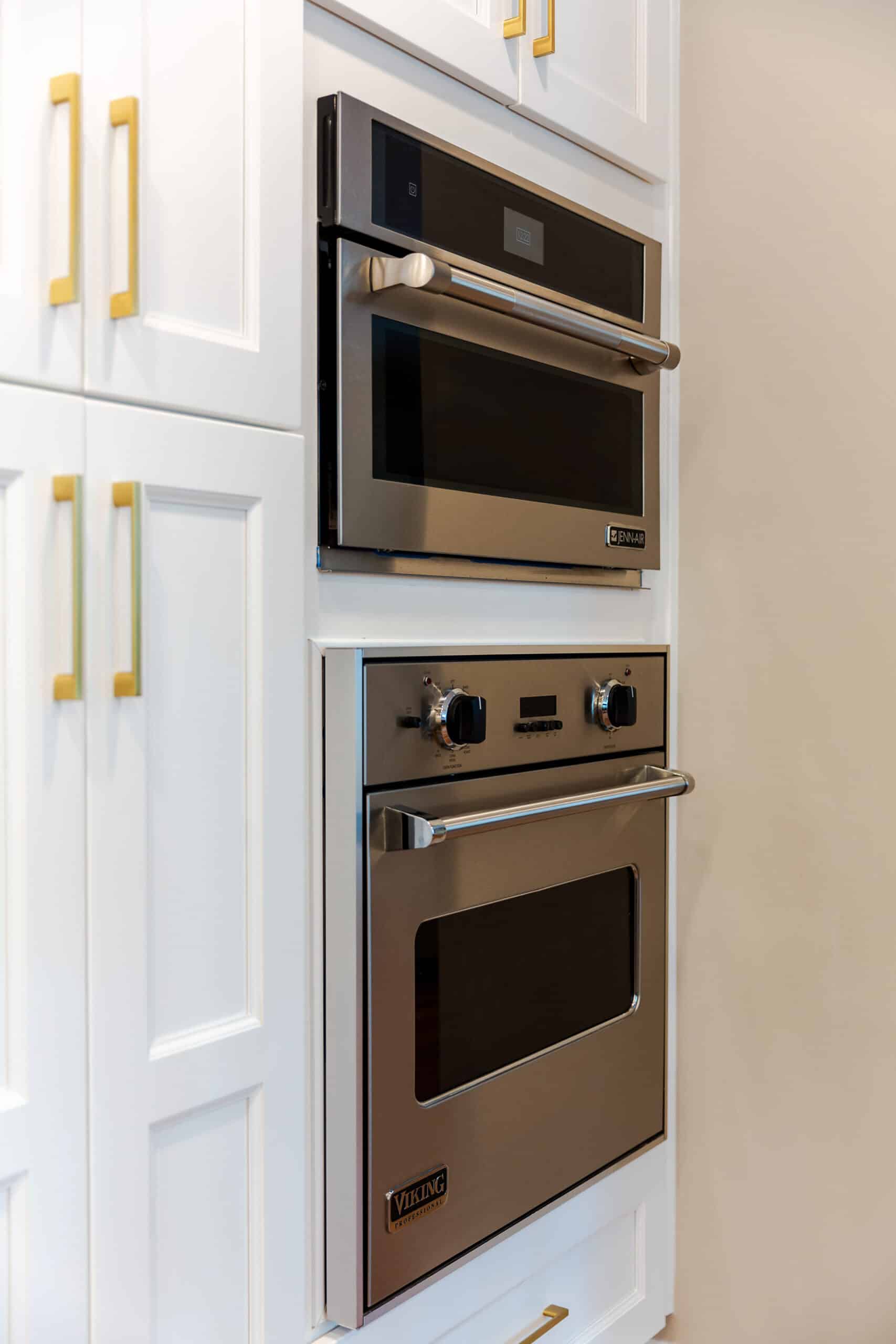 A white kitchen cabinets with two ovens