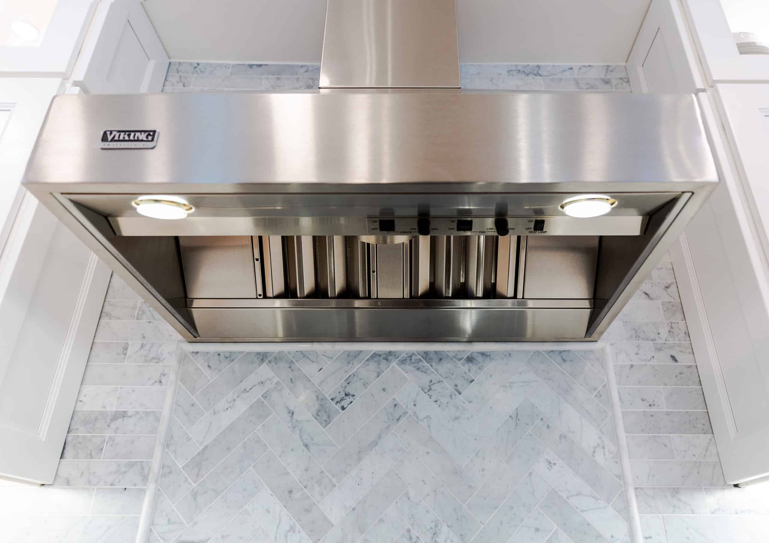 A kitchen with a stainless steel hood