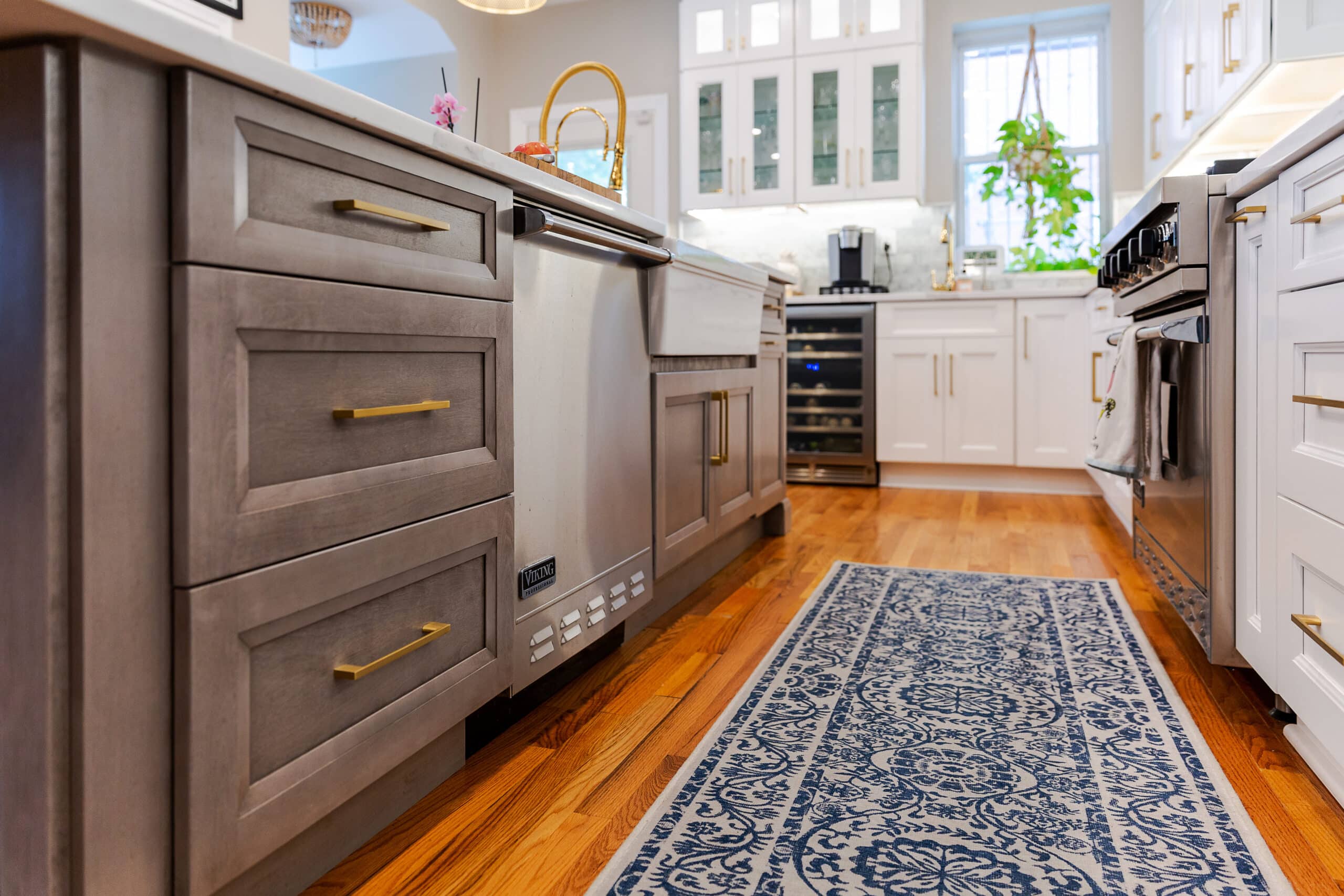 A kitchen with brown and white cabinets and a blue rug