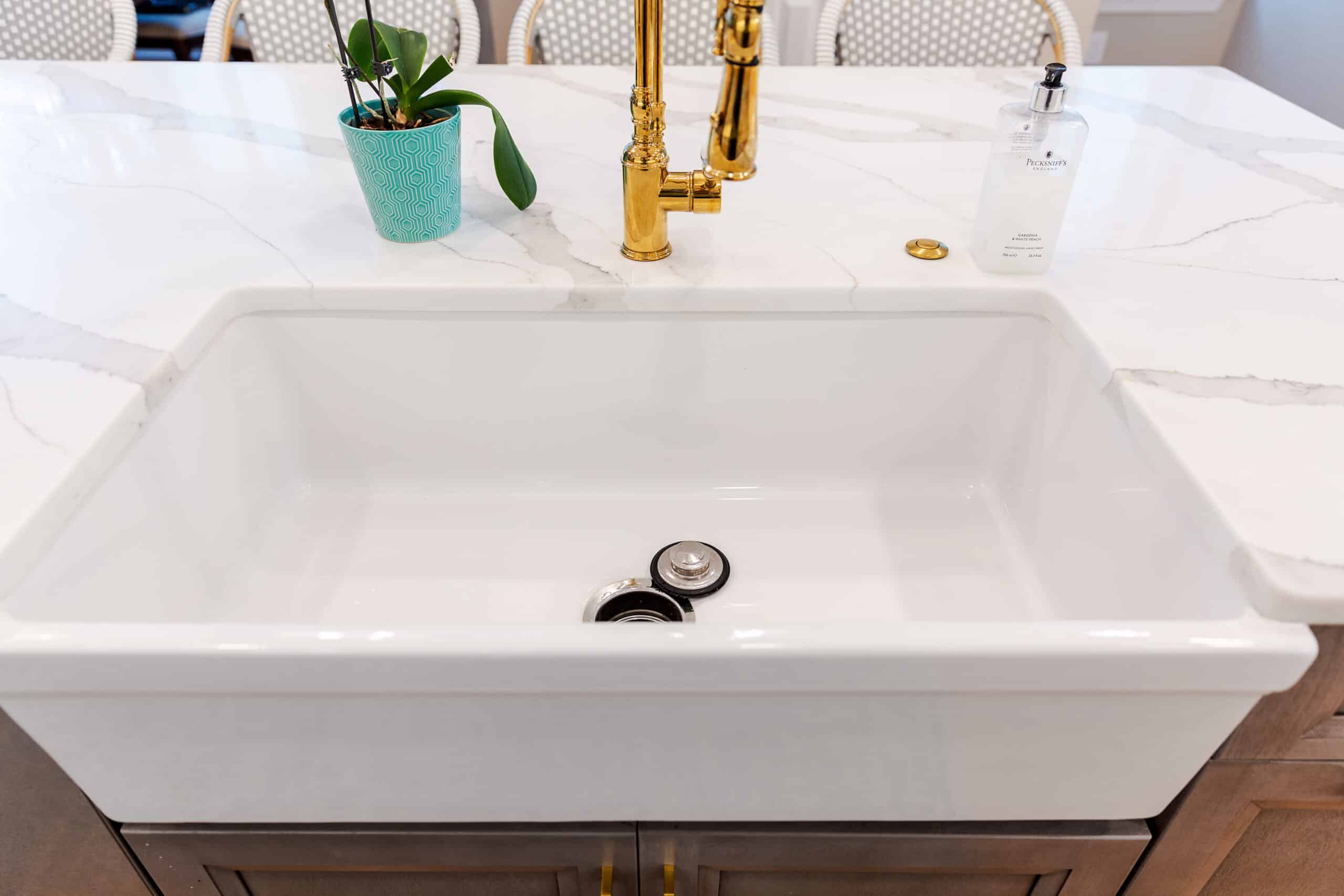 A luxurious kitchen sink featuring a gold faucet