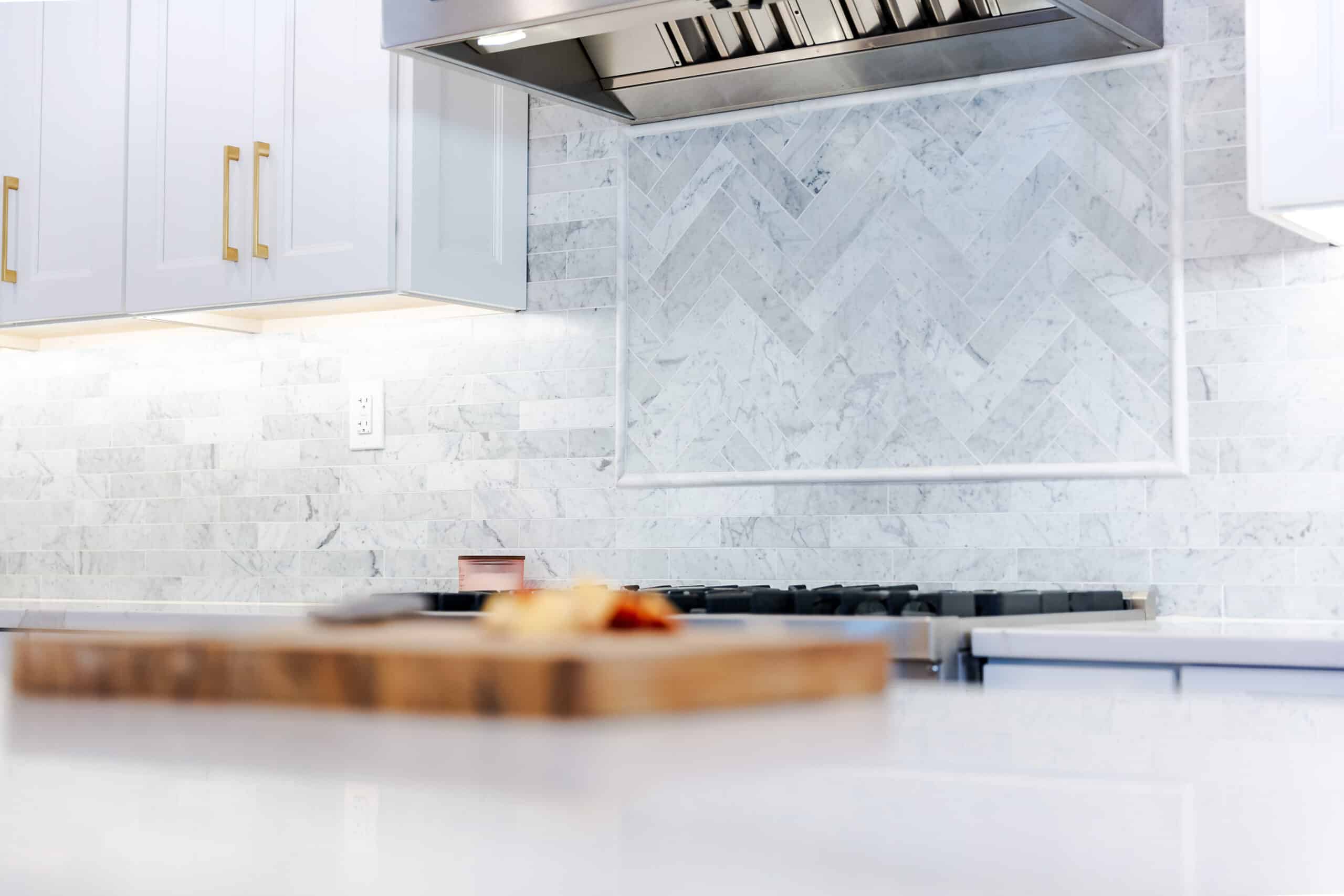 A kitchen with sleek white marble countertops and a modern stainless steel oven