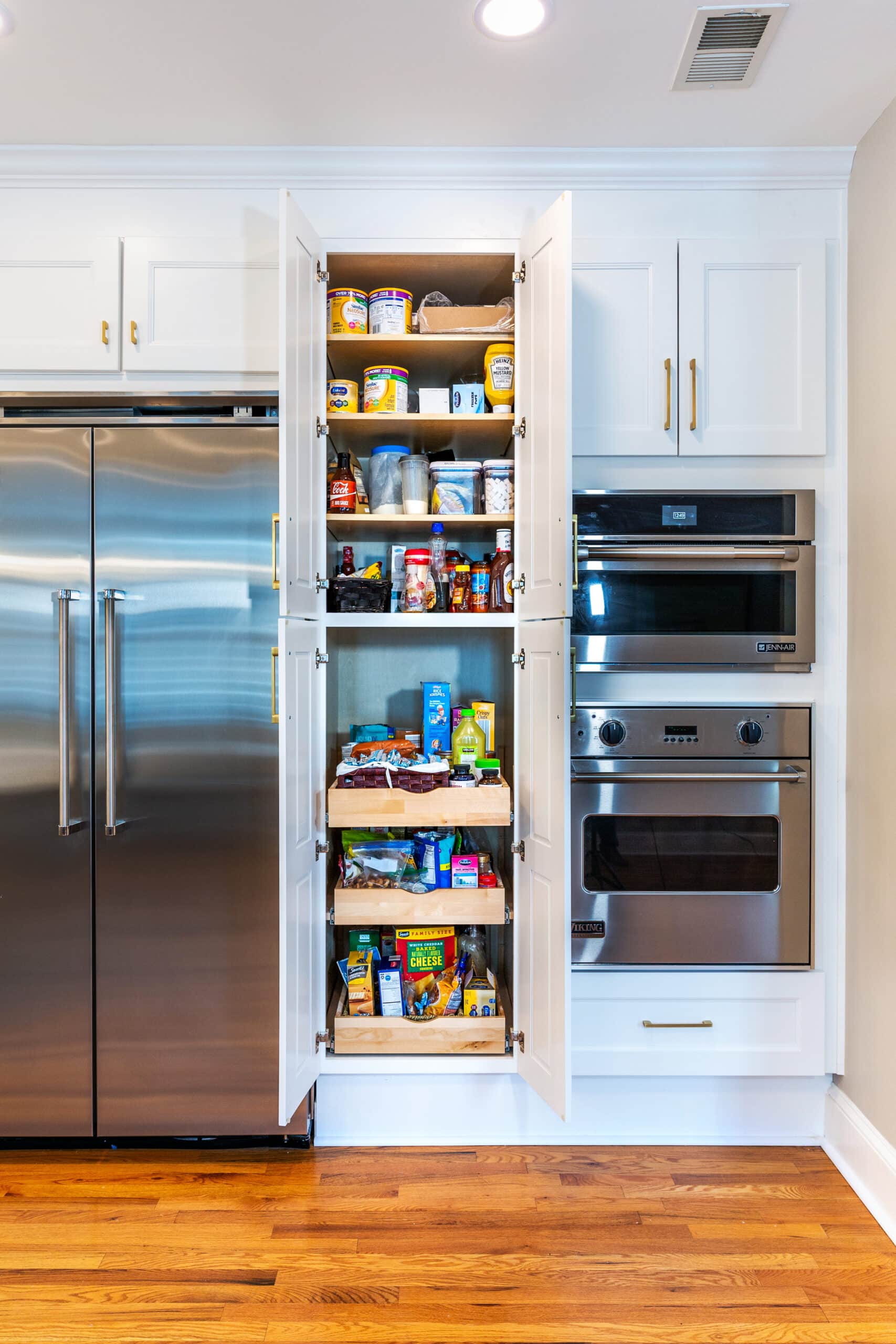 A well-stocked kitchen with a fridge and pantry