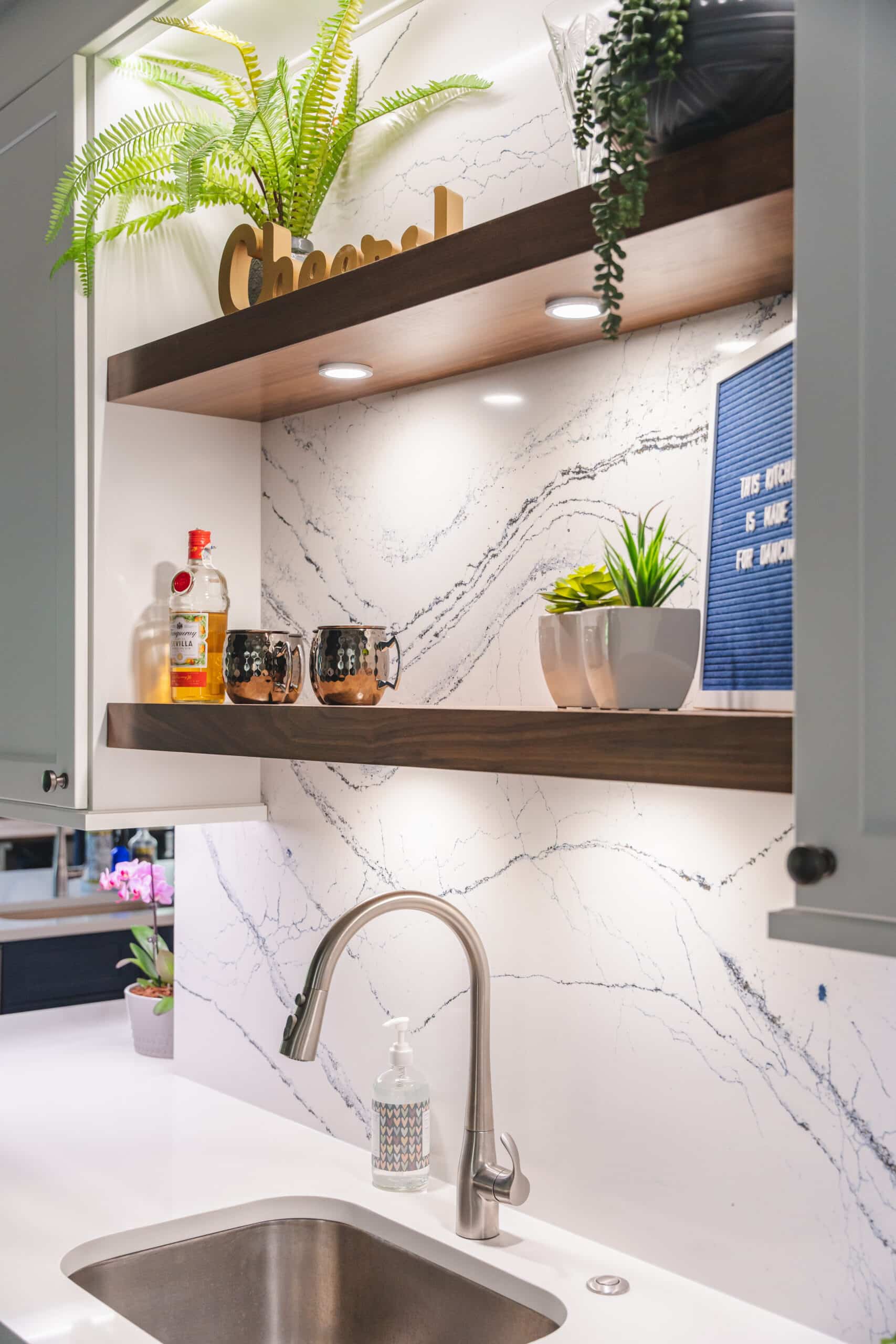 A functional kitchen sink with a shelf positioned above