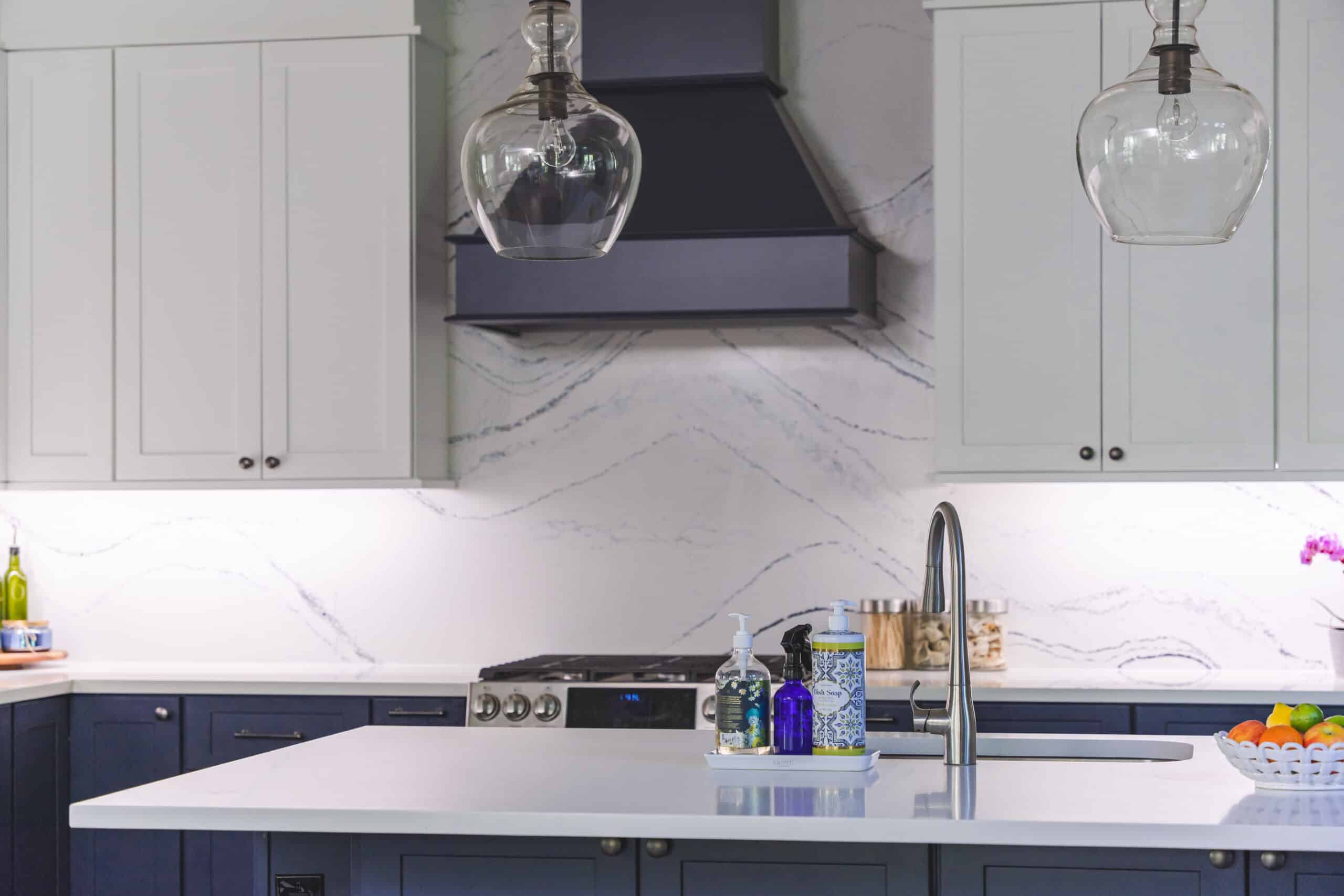 A kitchen with dark blue cabinets and white countertops