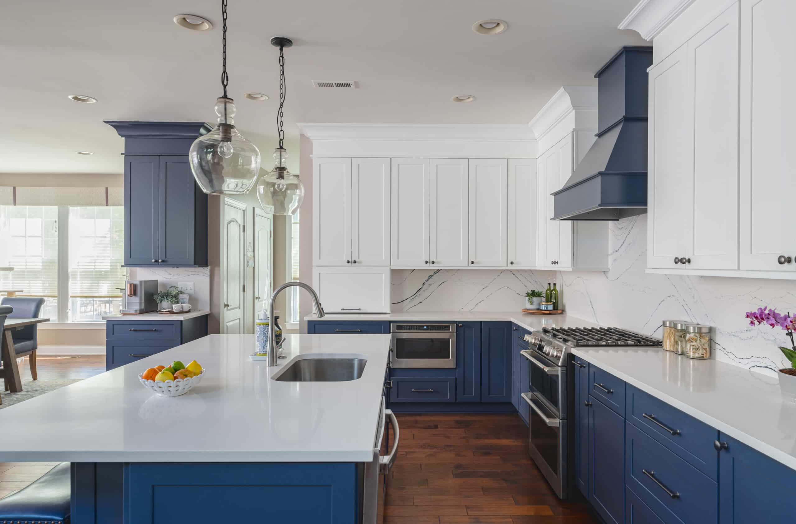 A kitchen with white and blue cabinets and white counter tops