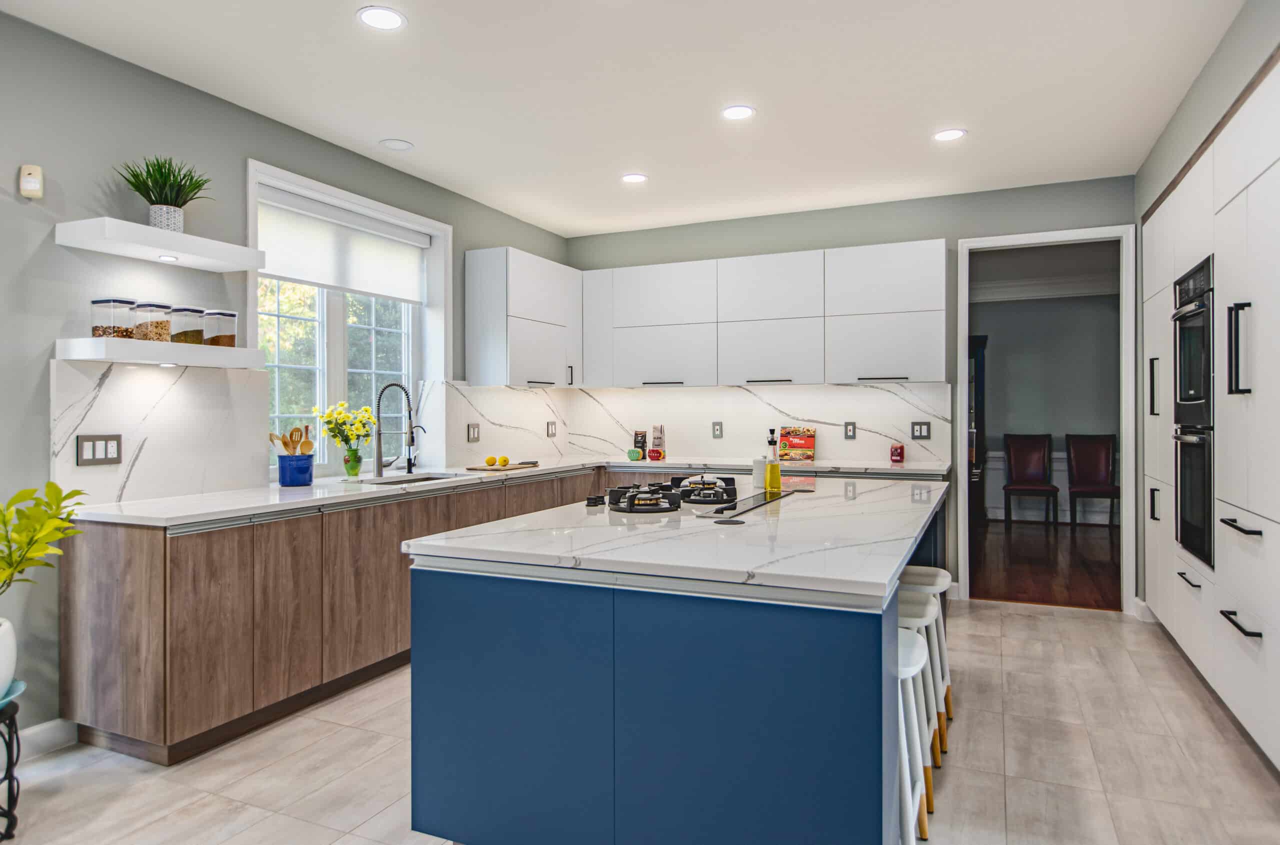 A kitchen with blue cabinets and white countertops