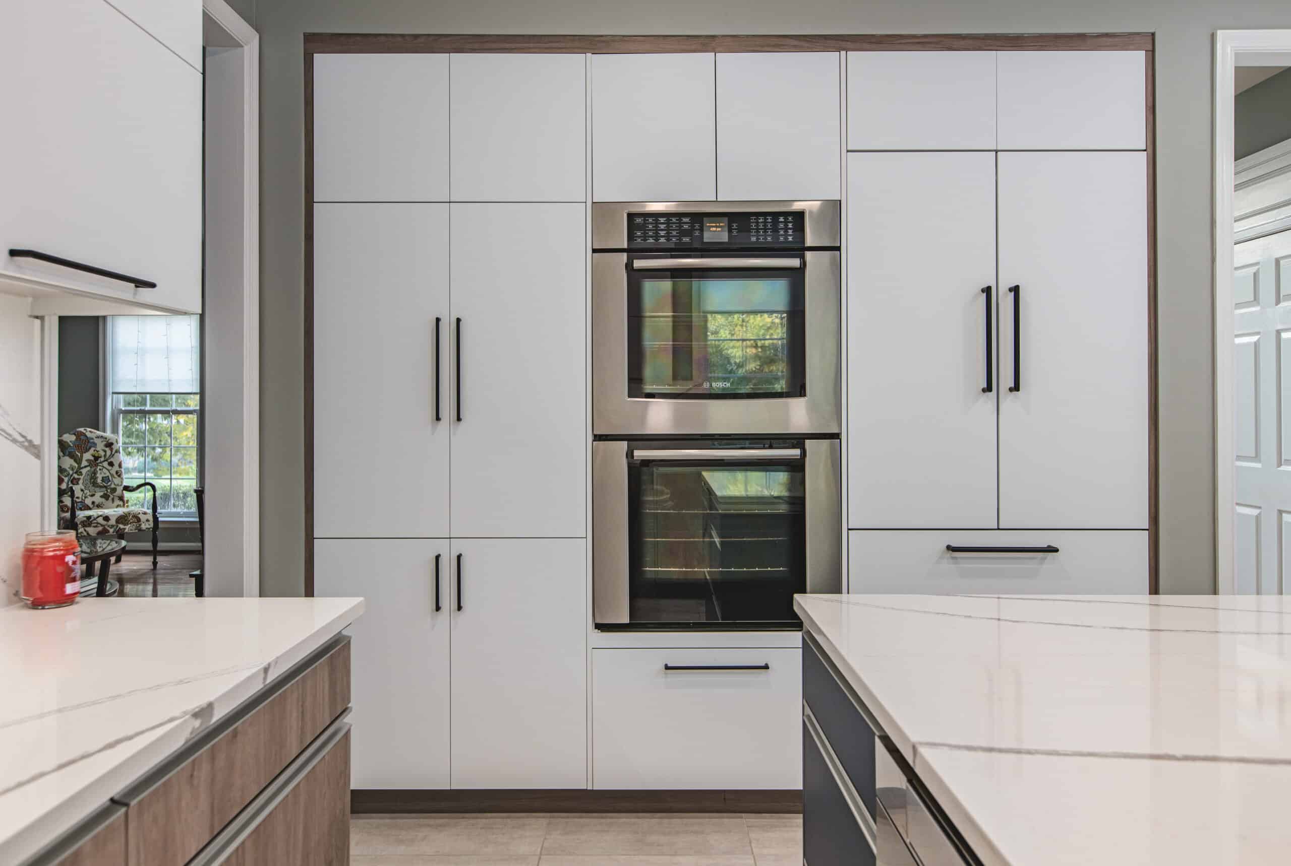 A modern kitchen with sleek stainless steel appliances and pristine white cabinets