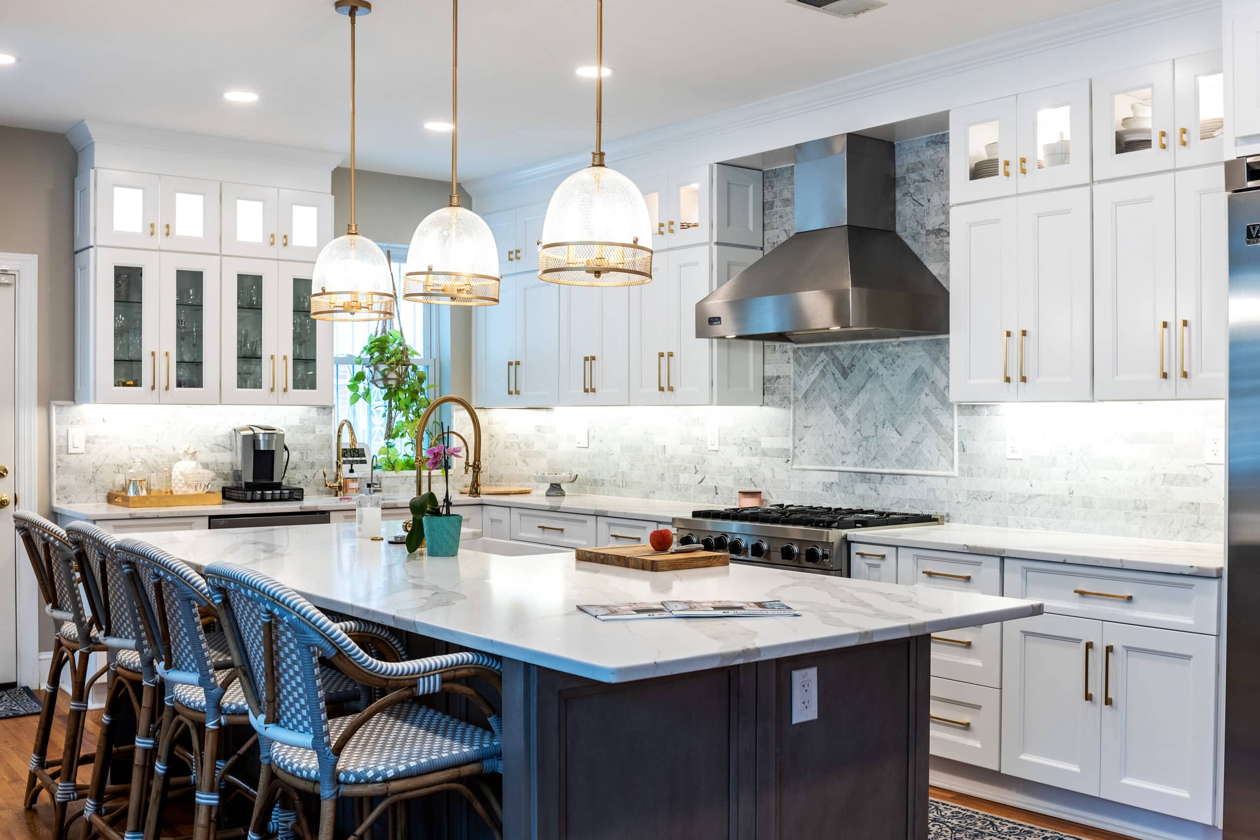 A kitchen with white cabinets and a marble island