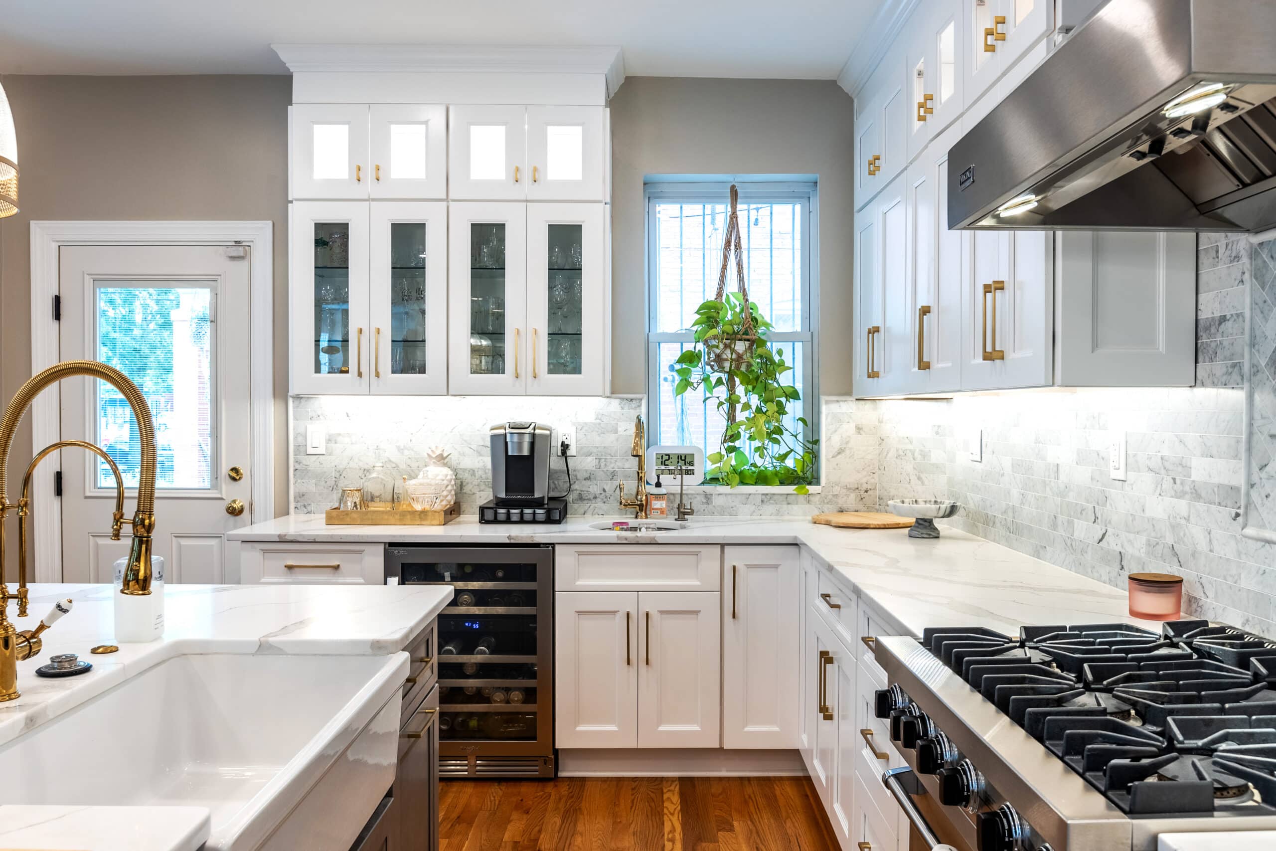 A kitchen with white cabinets and brass fixtures